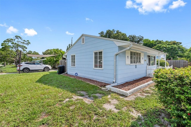 view of side of home with fence and a lawn