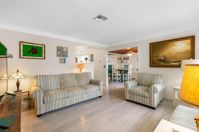 living room featuring ceiling fan and light hardwood / wood-style floors