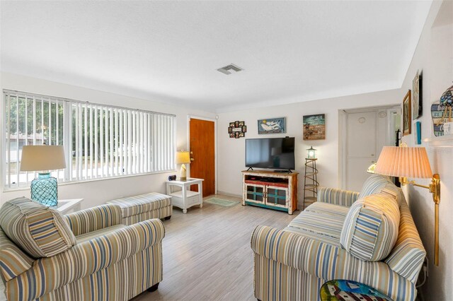 living area with visible vents and wood finished floors