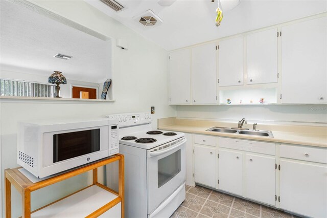 kitchen with sink, white cabinetry, white appliances, and light tile patterned floors