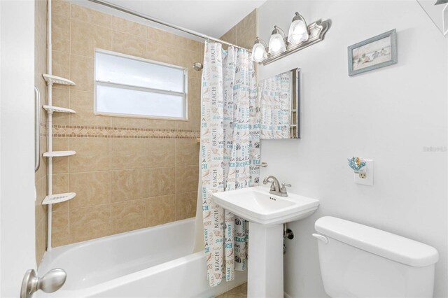 bathroom with toilet and shower / bathtub combination with curtain