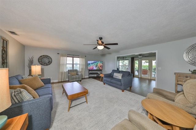 living room with ceiling fan, a textured ceiling, a healthy amount of sunlight, and hardwood / wood-style floors