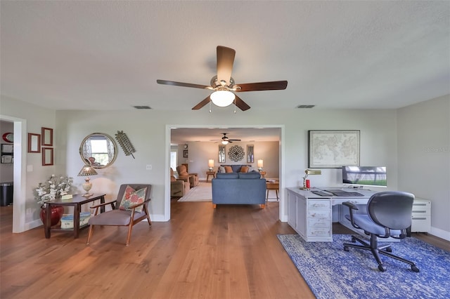 office featuring ceiling fan, plenty of natural light, and hardwood / wood-style flooring