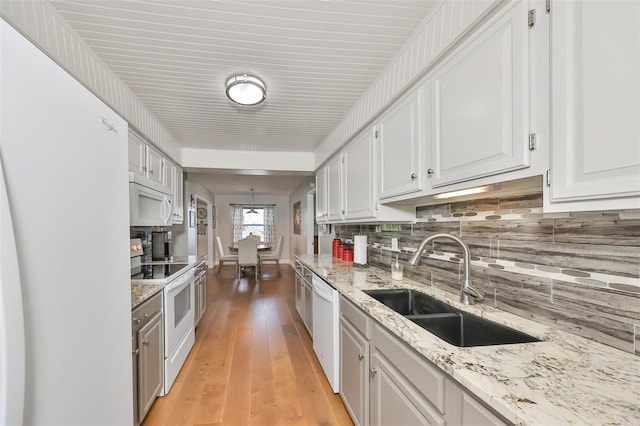 kitchen with decorative backsplash, light hardwood / wood-style flooring, white cabinetry, white appliances, and sink