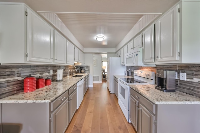 kitchen featuring light hardwood / wood-style flooring, white appliances, gray cabinetry, tasteful backsplash, and sink