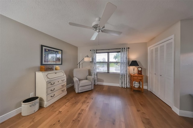 unfurnished room with ceiling fan, wood-type flooring, and a textured ceiling