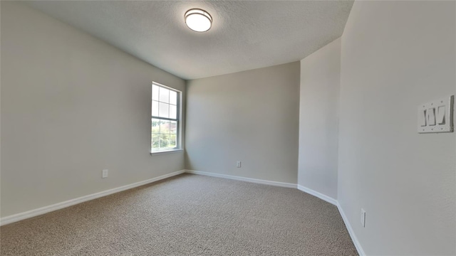 spare room featuring a textured ceiling and carpet flooring