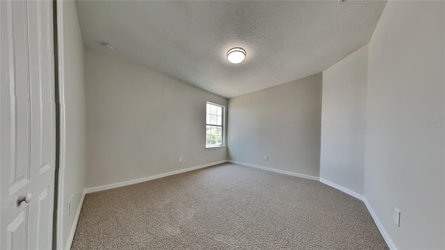 carpeted spare room with a textured ceiling