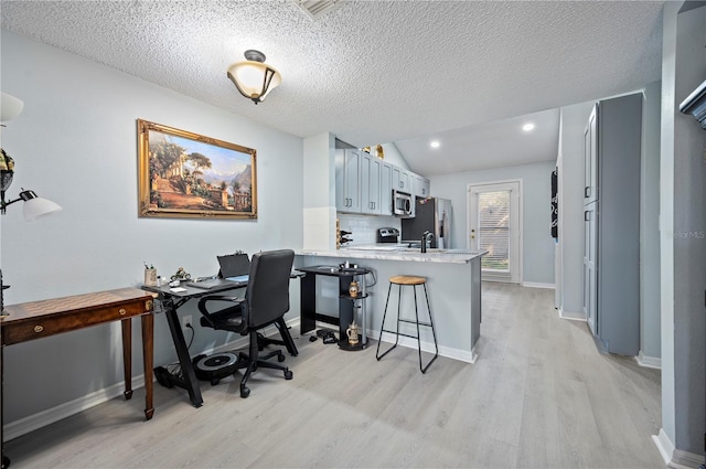 home office with lofted ceiling, a textured ceiling, recessed lighting, baseboards, and light wood-style floors