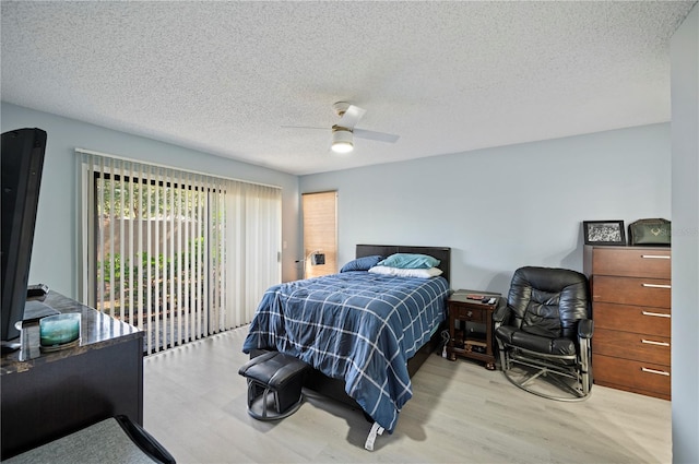 bedroom with access to outside, a textured ceiling, ceiling fan, and wood finished floors