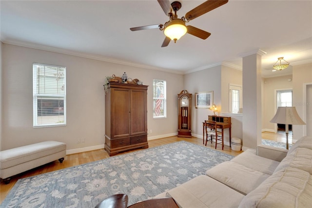 living room with light wood finished floors, plenty of natural light, ornamental molding, and baseboards