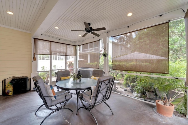 sunroom / solarium featuring a healthy amount of sunlight, wood ceiling, and a ceiling fan