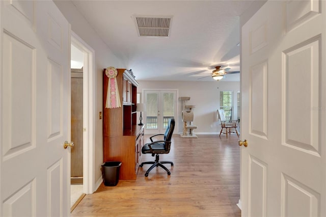 home office featuring french doors, visible vents, light wood-style flooring, ceiling fan, and baseboards