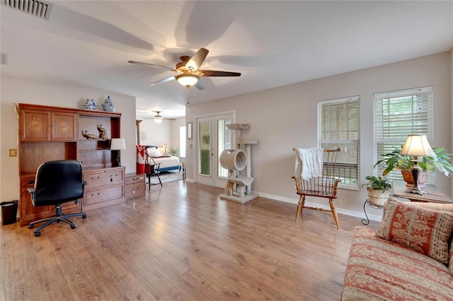 home office featuring baseboards, ceiling fan, visible vents, and light wood-style floors