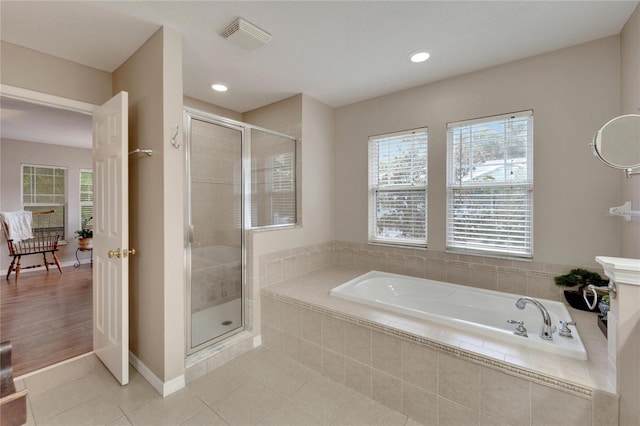 bathroom with a garden tub, visible vents, baseboards, tile patterned floors, and a stall shower