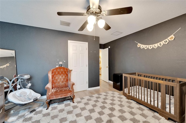 bedroom with visible vents, ceiling fan, baseboards, and wood finished floors