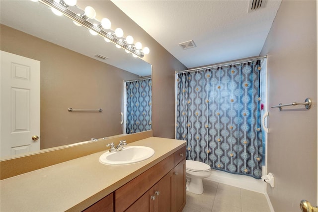 bathroom with toilet, vanity, tile patterned flooring, and visible vents