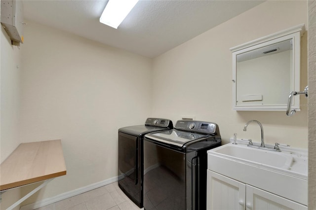 clothes washing area featuring light tile patterned floors, a sink, visible vents, independent washer and dryer, and cabinet space