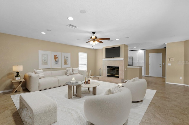 living room featuring ceiling fan, light tile patterned flooring, and a fireplace