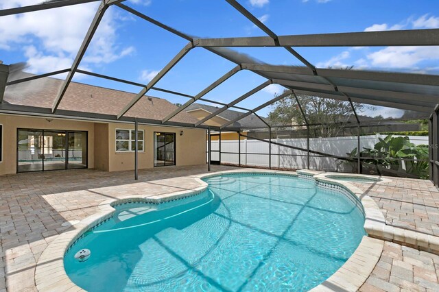 view of swimming pool with glass enclosure and a patio area