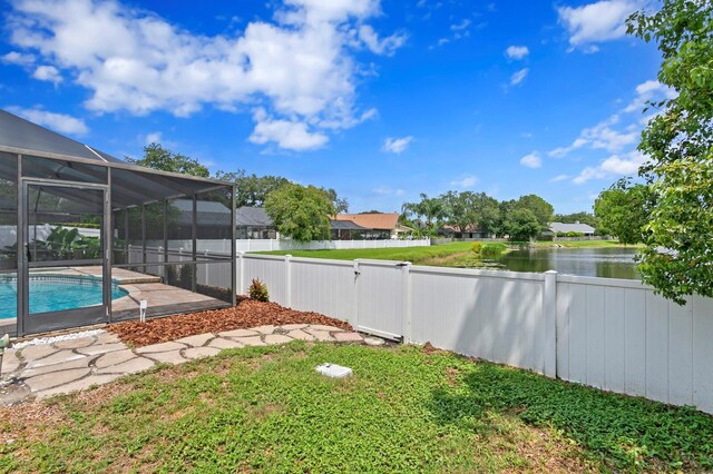 view of yard with glass enclosure and a fenced in pool