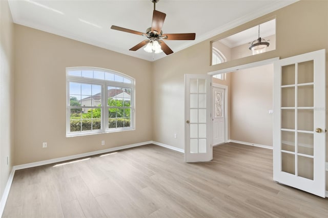 unfurnished room with baseboards, ceiling fan, ornamental molding, french doors, and light wood-type flooring