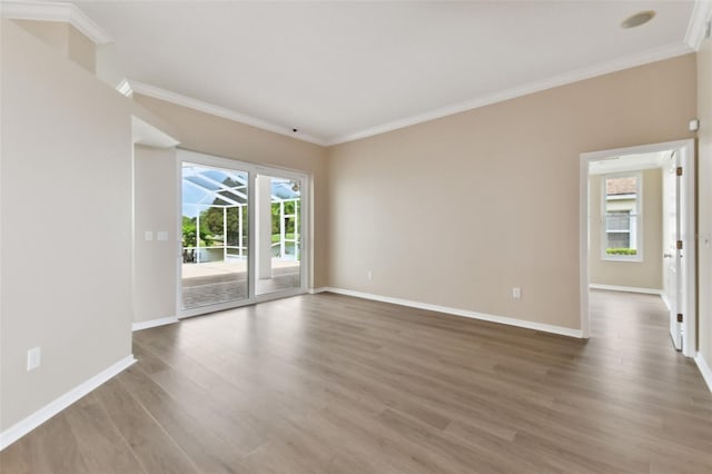 unfurnished room with crown molding, baseboards, and wood finished floors