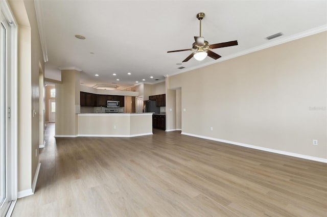 unfurnished living room with baseboards, visible vents, a ceiling fan, ornamental molding, and light wood-type flooring