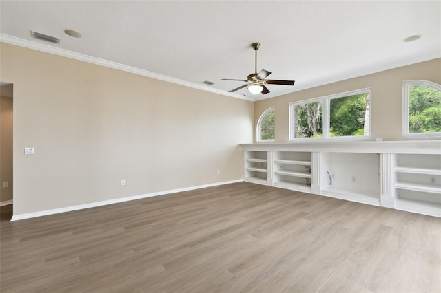 spare room with ornamental molding, visible vents, and wood finished floors