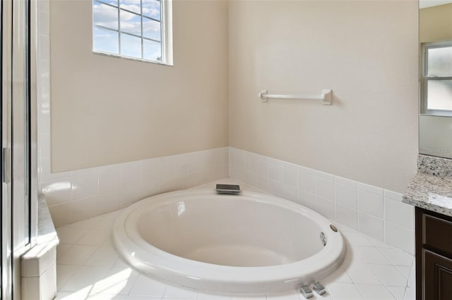 bathroom featuring a garden tub and vanity