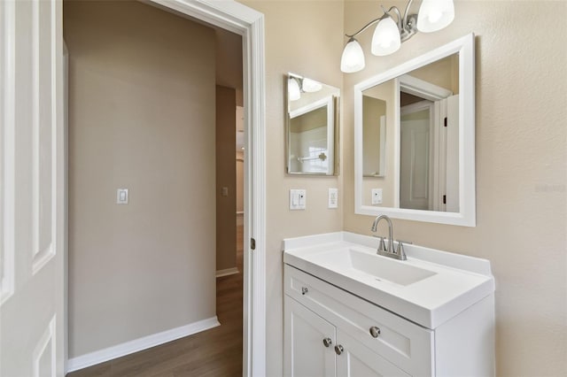 bathroom with vanity, baseboards, and wood finished floors