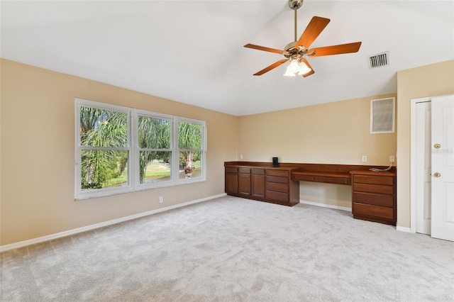 interior space featuring lofted ceiling, light carpet, a ceiling fan, visible vents, and baseboards