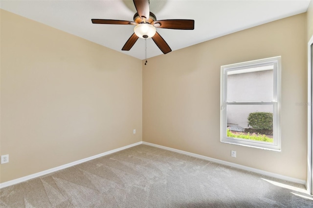 unfurnished room featuring light carpet, a ceiling fan, and baseboards