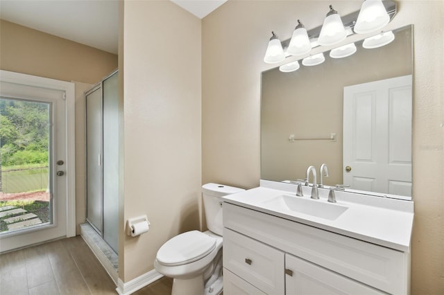 full bath with toilet, wood finished floors, a shower stall, and vanity