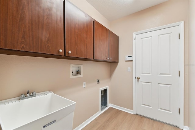 laundry area with washer hookup, cabinet space, a sink, electric dryer hookup, and light wood-type flooring