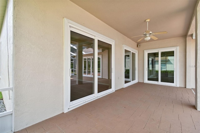 unfurnished sunroom featuring ceiling fan