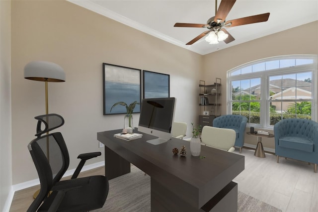 office space featuring light wood finished floors, ornamental molding, a ceiling fan, and baseboards