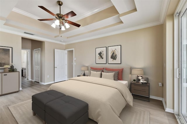 bedroom featuring visible vents, a tray ceiling, and light wood-style flooring