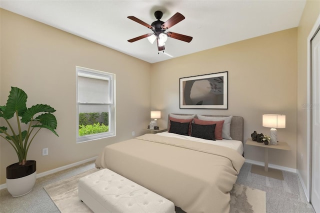 bedroom with ceiling fan, light colored carpet, and baseboards