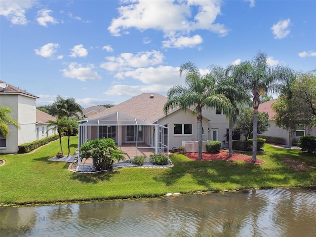 back of property featuring a water view, glass enclosure, a lawn, and stucco siding