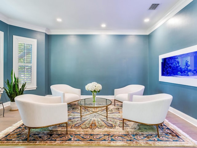 sitting room with crown molding and hardwood / wood-style flooring