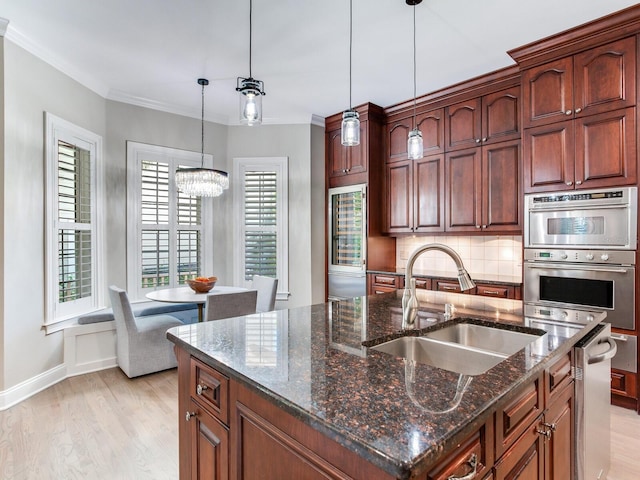 kitchen with tasteful backsplash, stainless steel appliances, dark stone counters, light hardwood / wood-style flooring, and sink