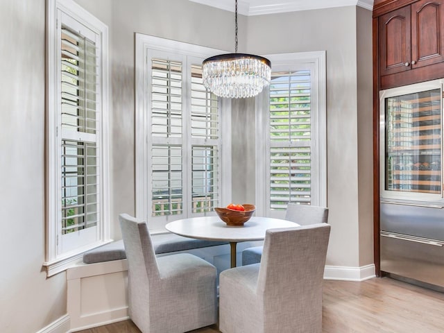 dining area featuring ornamental molding, a chandelier, and light hardwood / wood-style floors