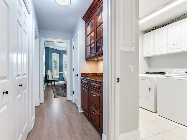 laundry area with cabinets, light wood-type flooring, and independent washer and dryer