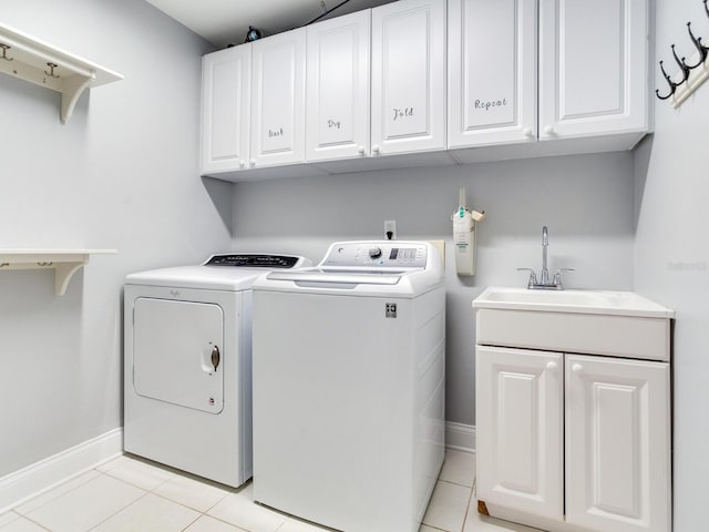 washroom with washing machine and dryer, sink, light tile patterned floors, and cabinets