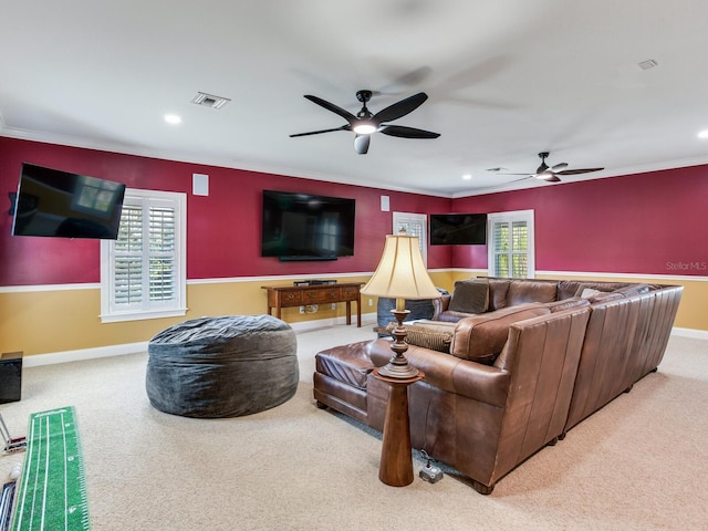 carpeted living room with ceiling fan and ornamental molding