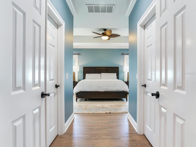 bedroom featuring ceiling fan, hardwood / wood-style floors, and crown molding