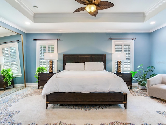 bedroom featuring ceiling fan, a raised ceiling, and multiple windows