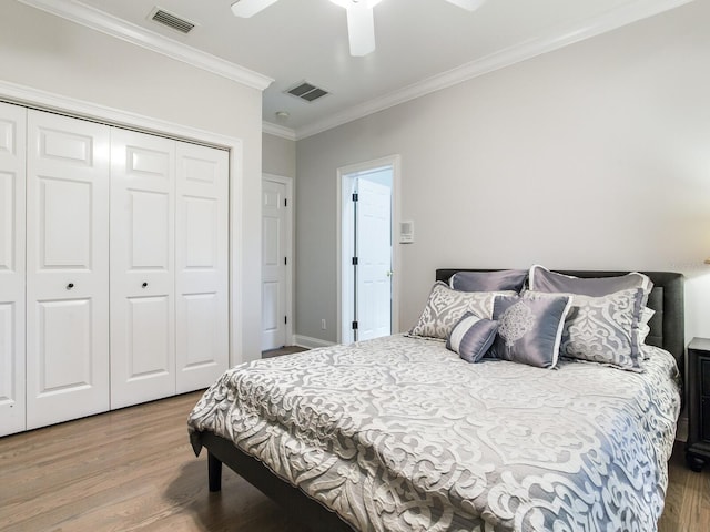 bedroom featuring a closet, light wood-type flooring, ornamental molding, and ceiling fan