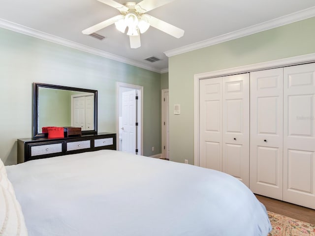 bedroom featuring ceiling fan, wood-type flooring, a closet, and crown molding